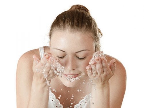 Chica limpiando su rostro con agua pura